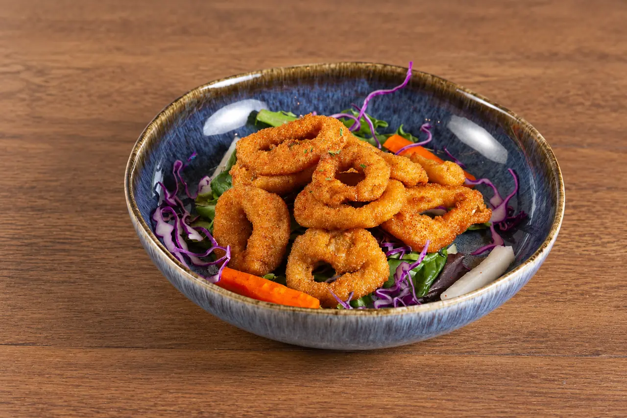 Crispy Calamari with salad garnish in a blue ceramic bowl.