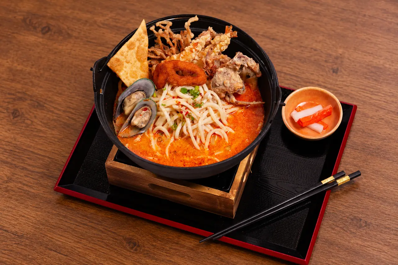 Royal Tom Yum Seafood with hot-and-sour broth, udon and seafood.