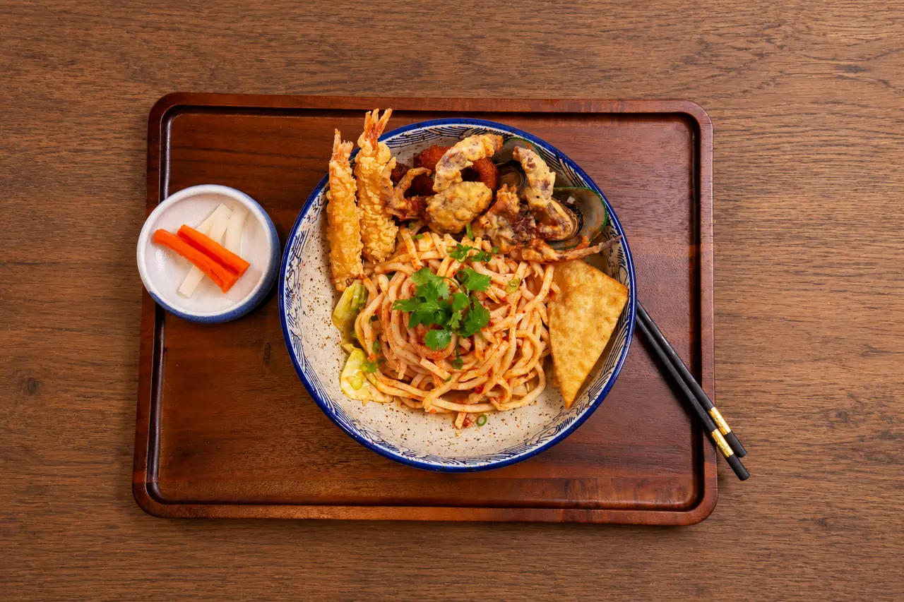 Tom Yum Noodles with tossed udon, tempura seafood, mussels and crispy wonton.